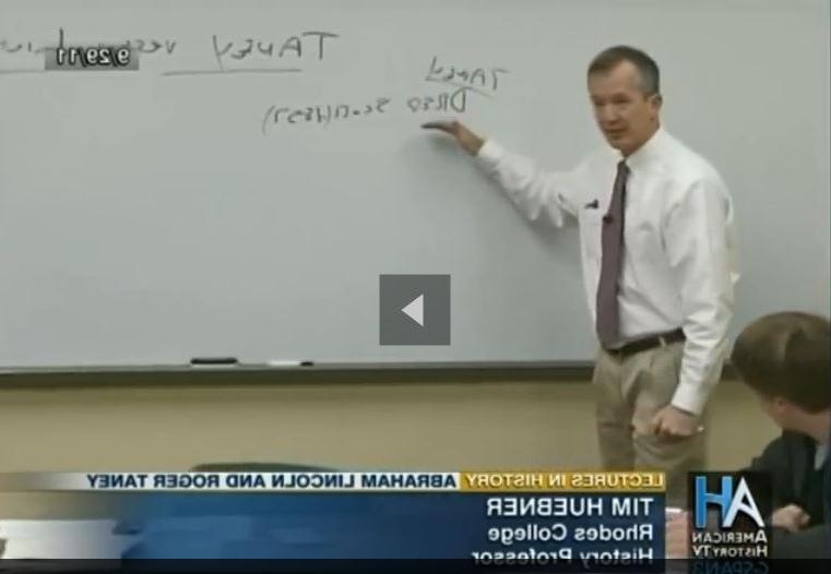 a professor in front of a white board