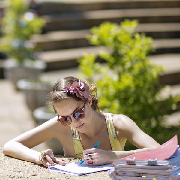 Young woman studying in the summer sun