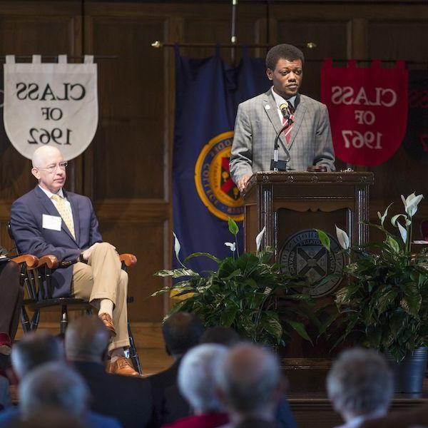 a young Black man speaks at a lectern