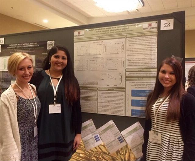 Students in front of a poster presenting research